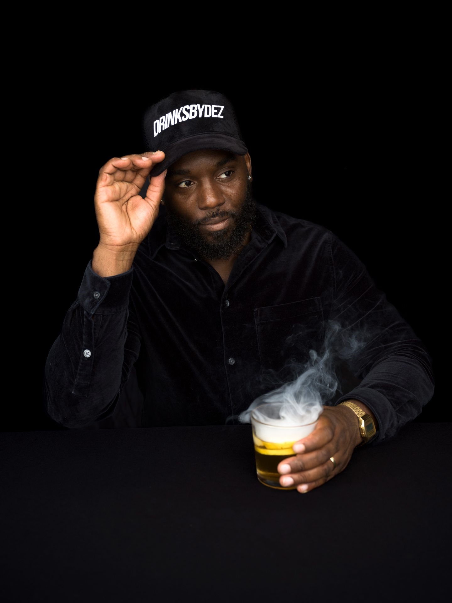 Dez wearing the DRINKSBYDEZ trucker hat